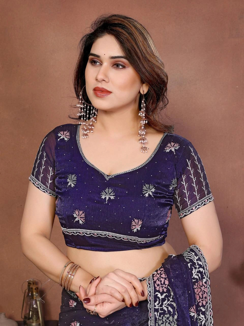 Woman wearing a purple blouse with floral patterns against a brown background